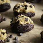 cookie dough stuffed dates on a wooden cutting board.