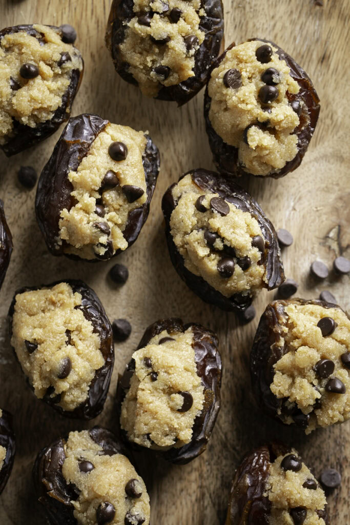 overhead shot of cookie dough stuffed dates on a wooden cutting board.