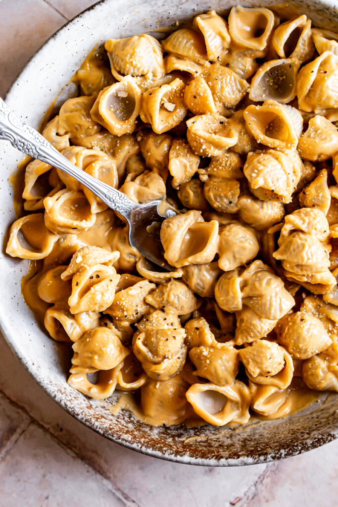 a close up of a bowl of Mac and cheese with a fork in it