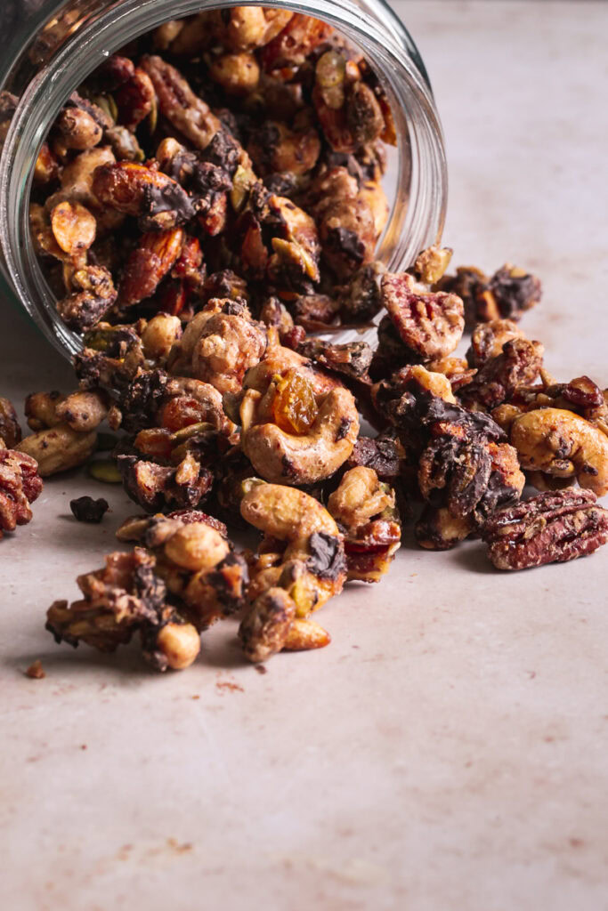 trail mix being dumped out onto a table from a glass jar
