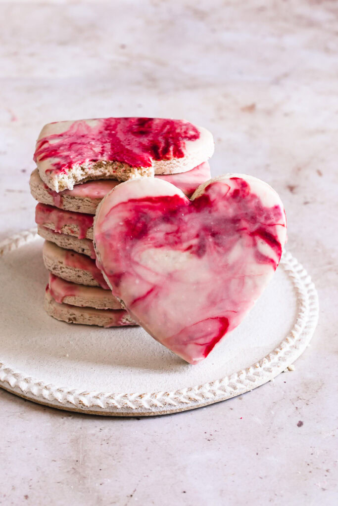 a stack of decorated sugar cookies with one proped up vertically in front of the stack