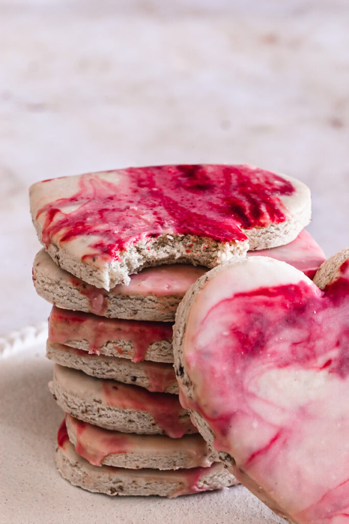 a close up of a stack of cookies, the top cookie with a bit take out of it