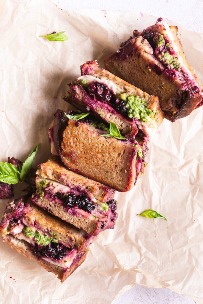 vegan blackberry pesto grilled cheese sandwich halves on a piece of parchment paper