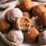a bowl of carrot cake granola bites with one of them taken a bite out of it