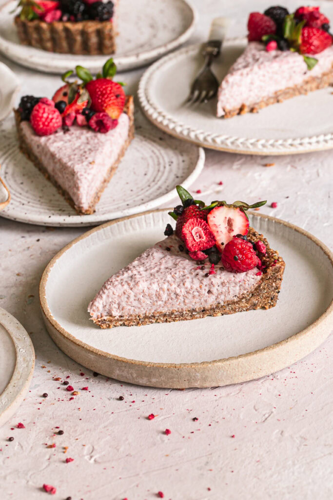 side view of slices of slices of breakfast chia yogurt granola tart decorated with fresh berries on plates