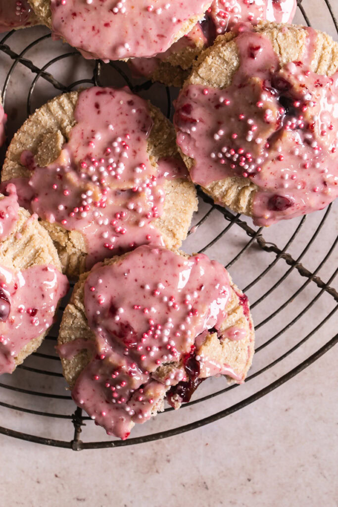 a close up of a round wire cooling rack with round cherry pop tarts overlapping on top