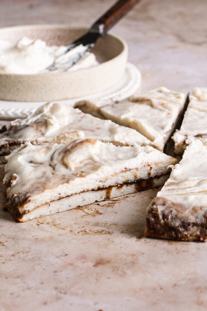 side view of the cinnamon roll pizza revealing the cinnamon sugar filling