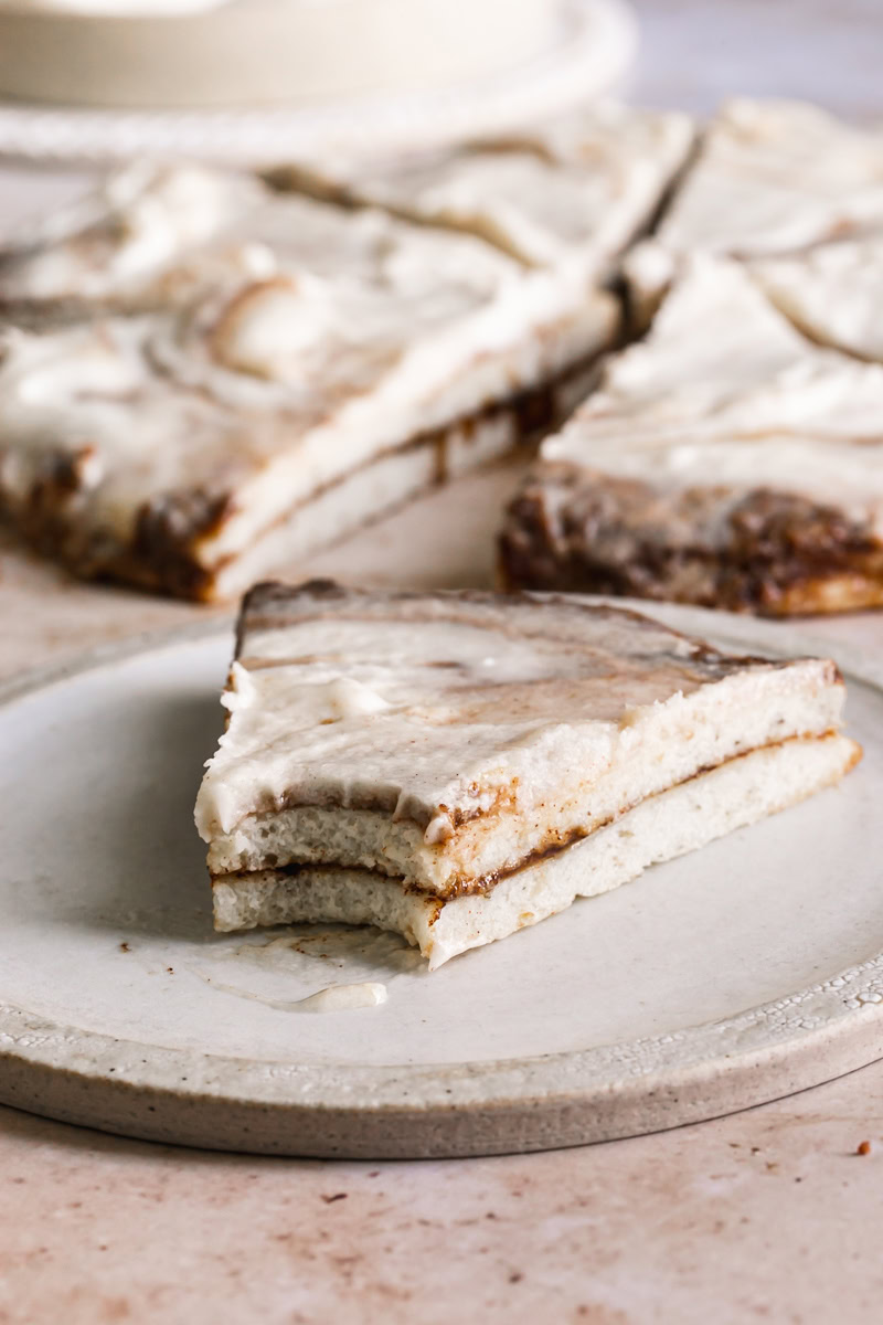 a slice of cinnamon roll pizza with a bite taken out of it