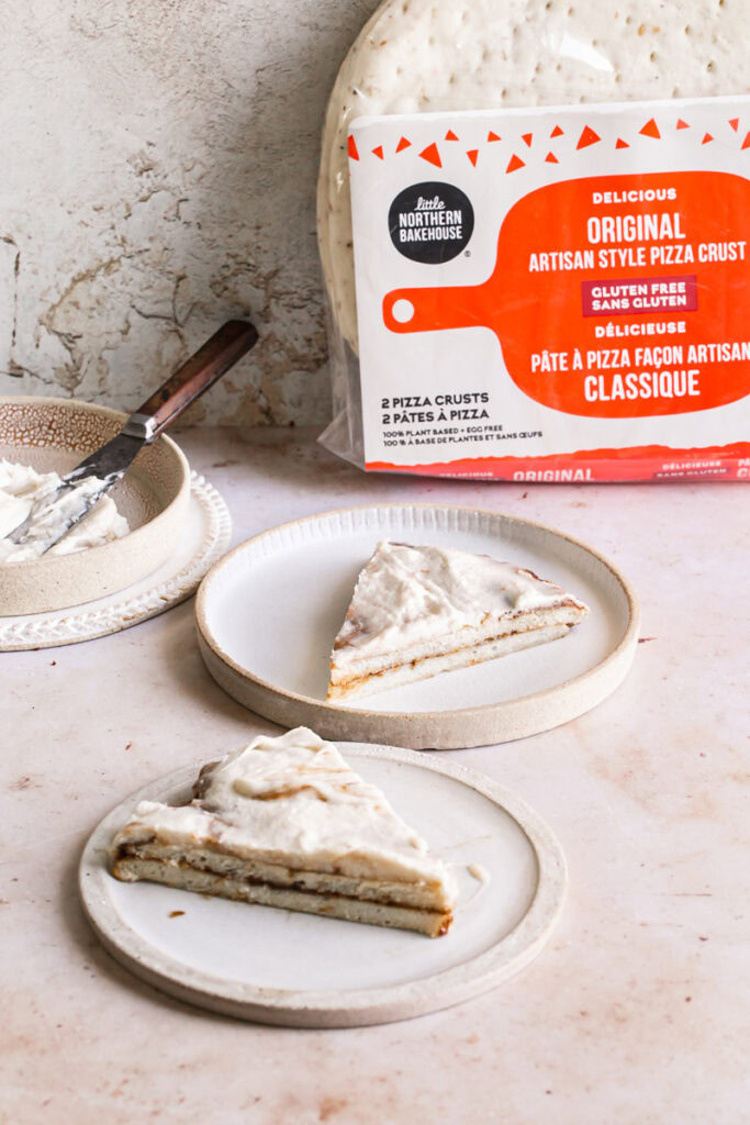two slices of cinnamon roll pizza with a pack of little northern bakehouse pizza crusts in the background