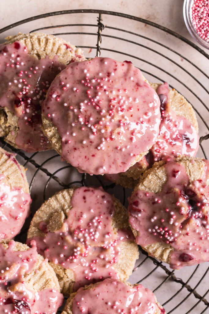 a close up of a round wire cooling rack with round cherry pop tarts overlapping on top.