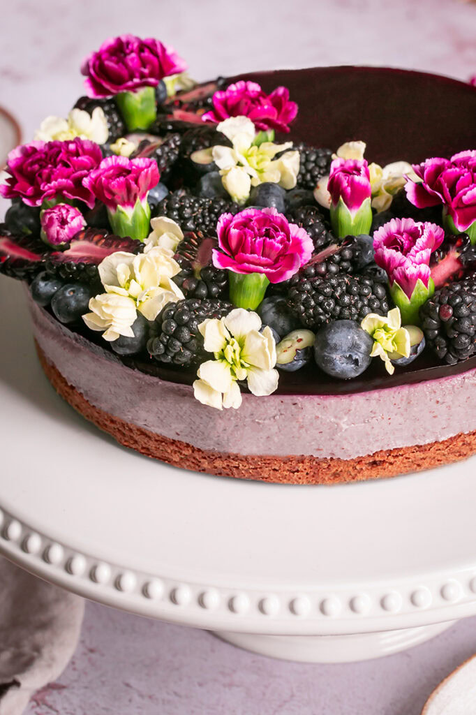 side view of haskap berry cheesecake on a cake plate
