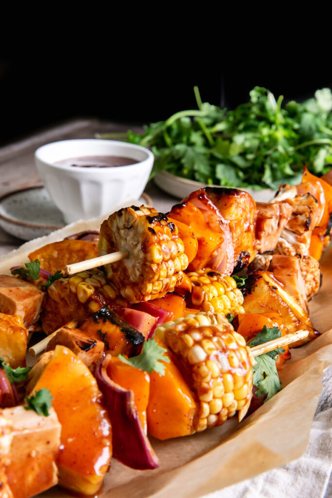 side view of plated grilled kabobs with cilantro in the background
