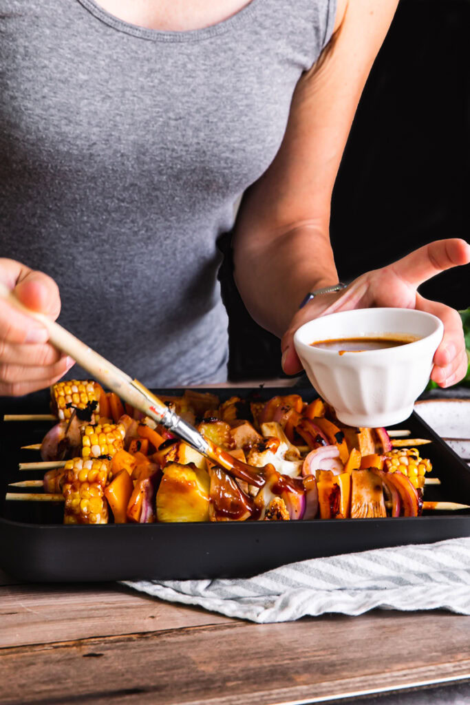 action shot of me bruising barbecue sauce over the kabobs in the Calphalon grill pan