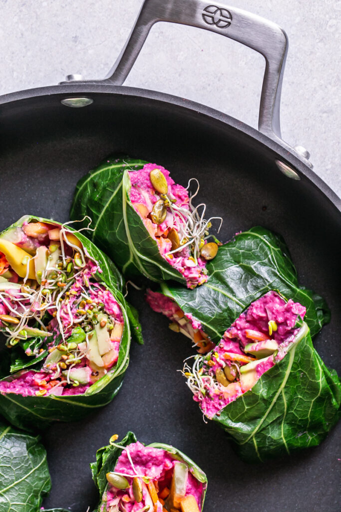 beet hummus veggie collar wraps cut in half placed inside a Calphalon skillet