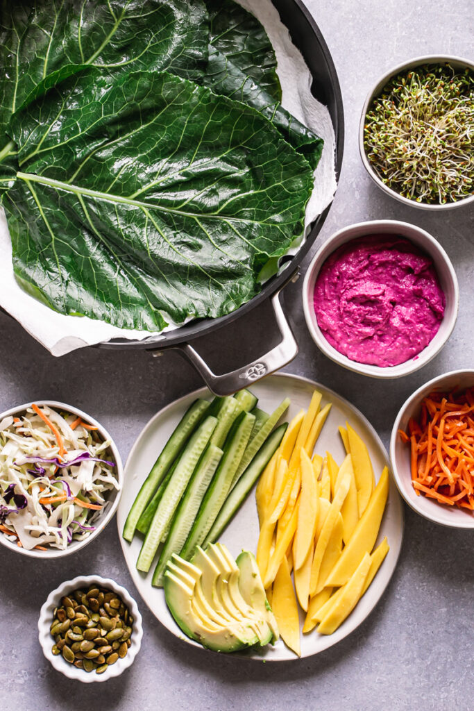 all of the ingredients to make these beet hummus veggie collard wraps laid out together
