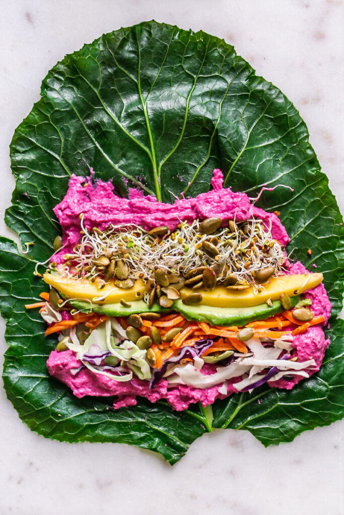 a blanched collard wrap laid out with all of the fillings inside before rolling