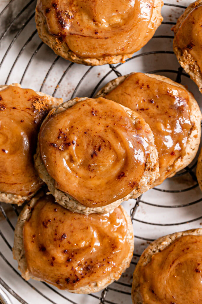 caramel apple cider cookies on a round wire baking rack topped with caramel 