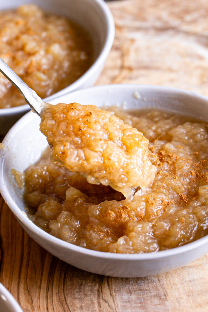 a bowl of Golden Delicious Applesauce with a spoon scooping some out