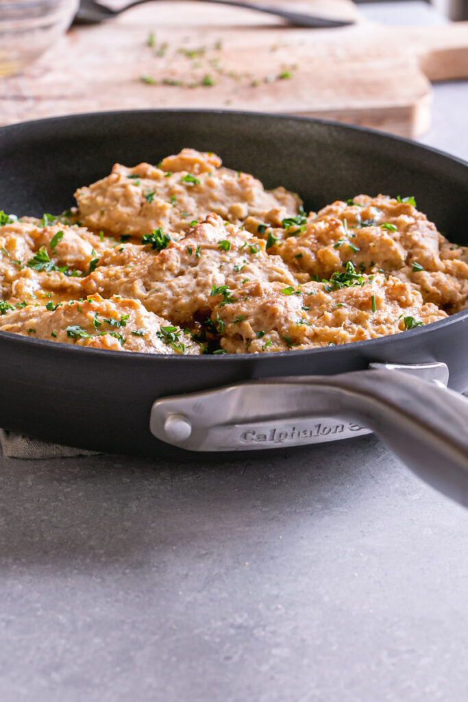 a 3/4 photo of the back of the Calphalon skillet with the baked biscuits inside