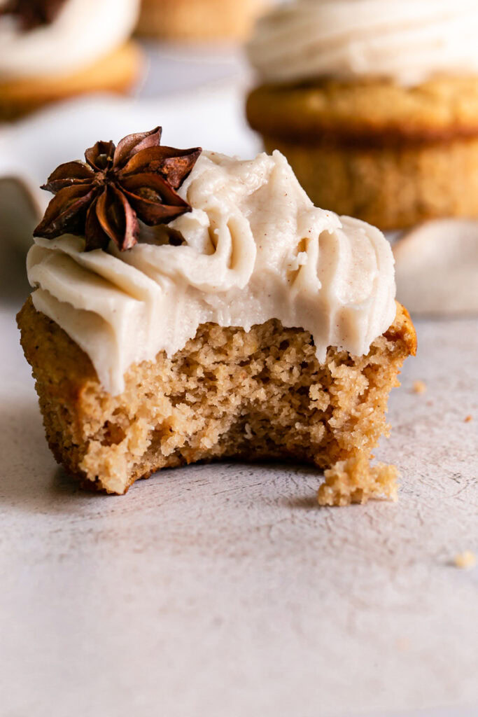 close up of a frosted chai cupcake with a bite taken out of it
