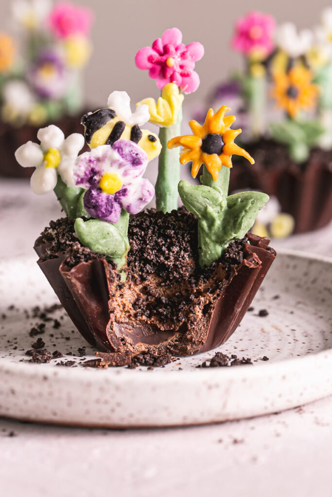 a close up of a close up of a Chocolate Avocado Pudding Dirt Cup with a bite taken out of it to reveal the avocado pudding filling