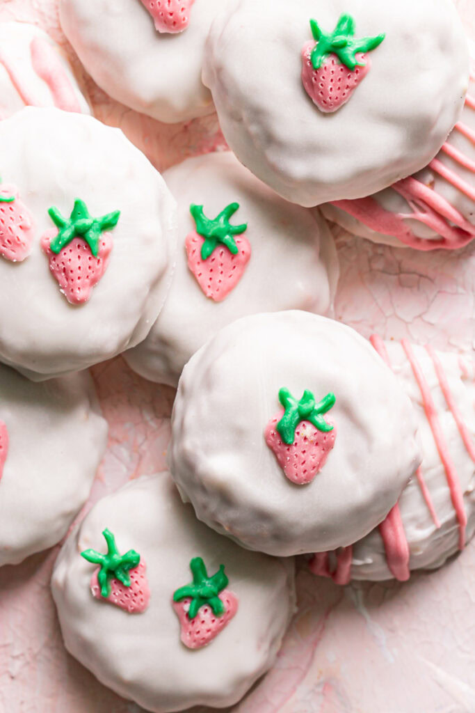 white chocolate covered strawberries and cream qunioa cookies decorated with a painted white chocolate strawberry