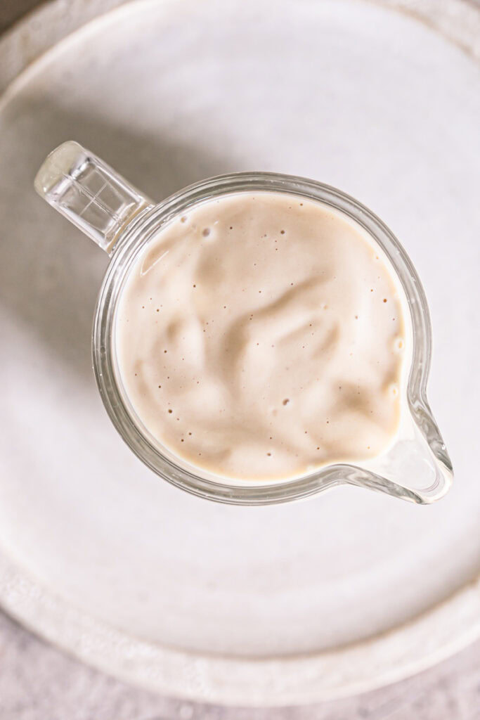 overhead shot of the creamy tahini dressing in a glass