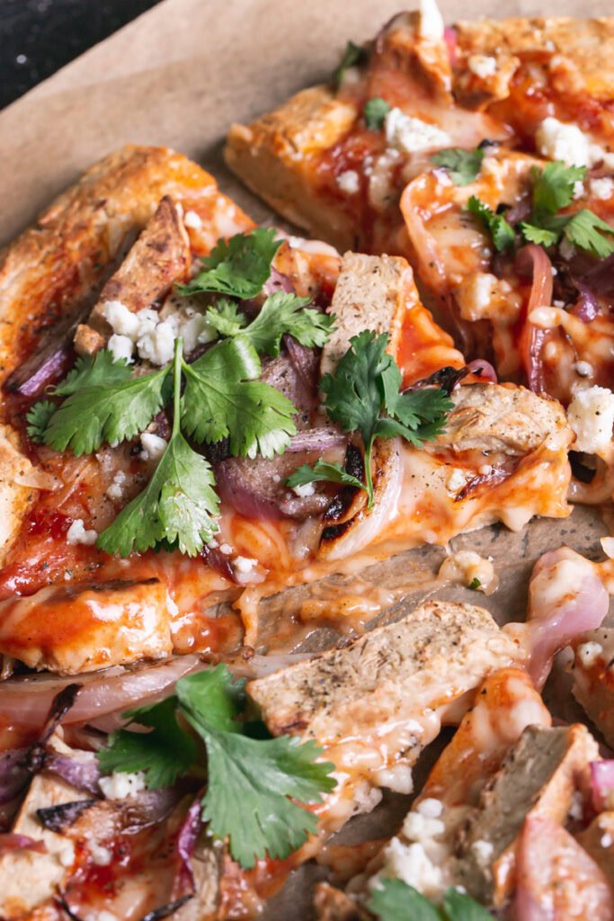 3/4 shot of a slice of Vegan BBQ Chicken Pizza