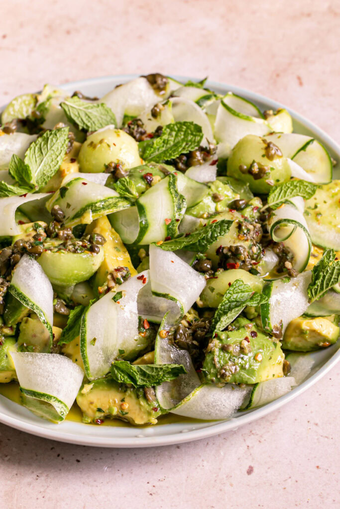 3/4 shot of a plate filled with Honeydew Avocado Cucumber Crudo on a plate