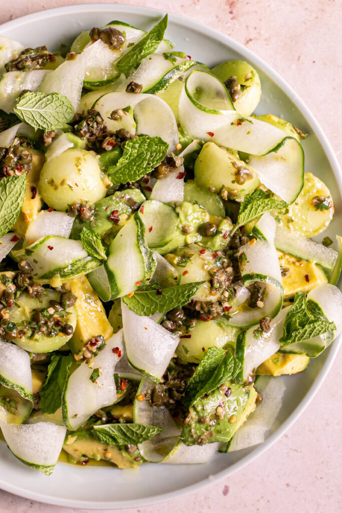 a close up of a plate filled with Honeydew Avocado Cucumber Crudo