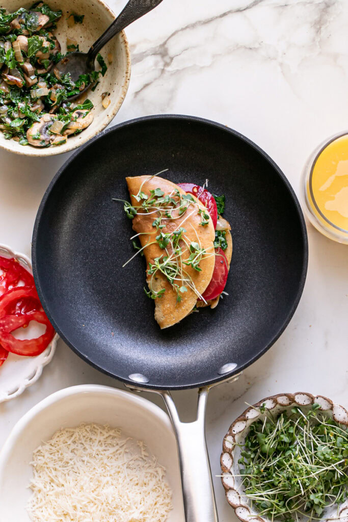 vegan gluten-free savory pancake filled in a pan with the ingredients all around the pan