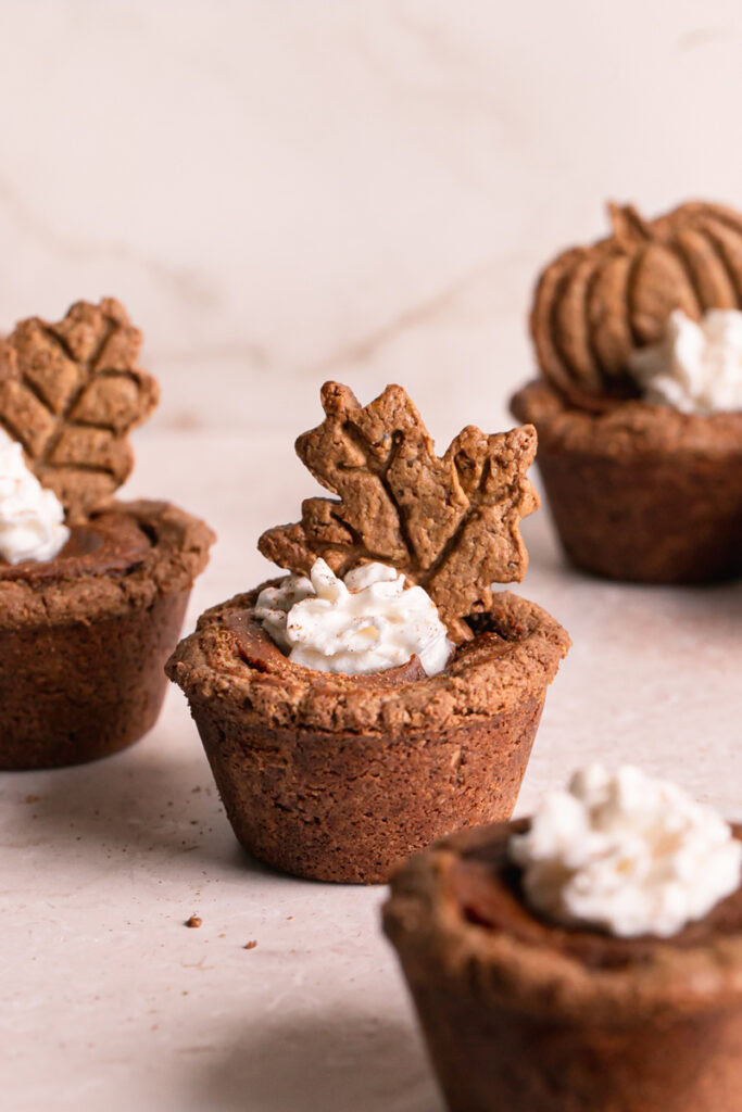pumpkin pie cookie cups decorated with whipped cream and the fall cookies