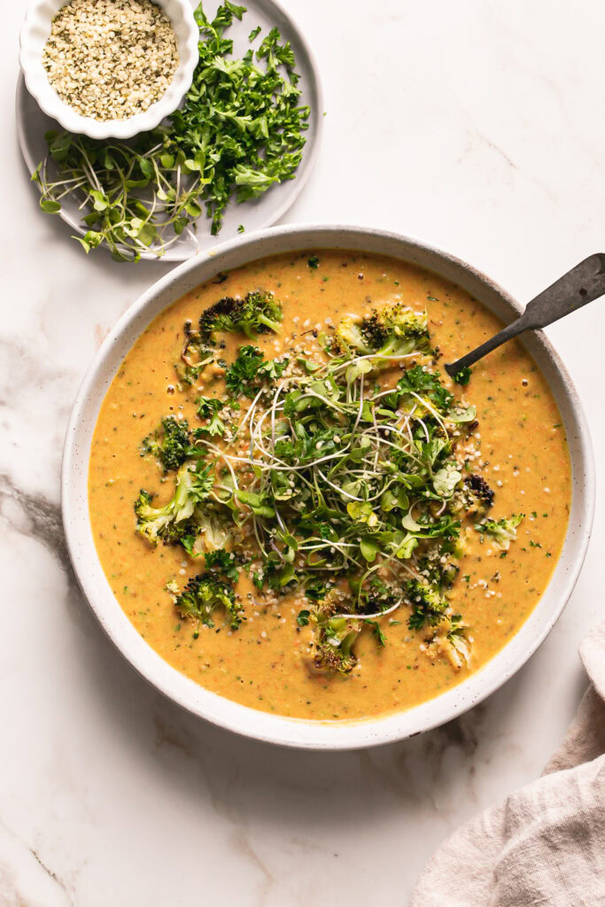 a close up overhead shot of Roasted Broccoli Potato Cheese Soup with a spoon in it