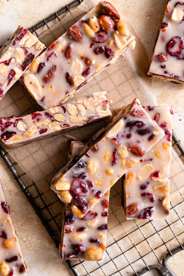 sliced White Chocolate Amaretto Trail Mix Truffle Bars on a parchment square on a rectangle cooling rack