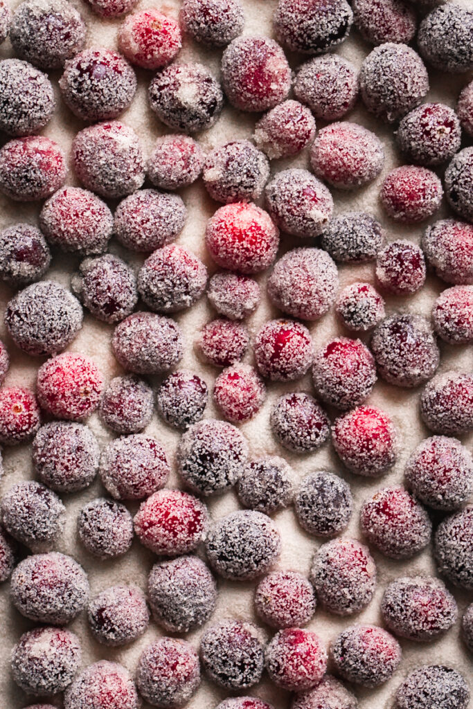 sugared cranberries spread out over sugar