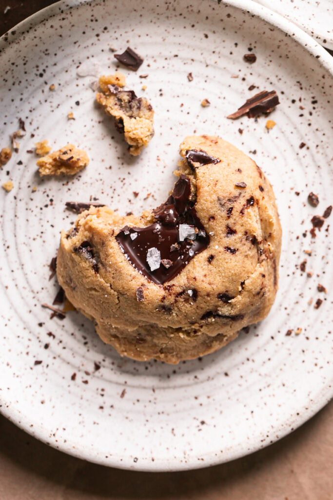 a peanut butter chocolate chunk cookie on a plate with a bite taken out of it