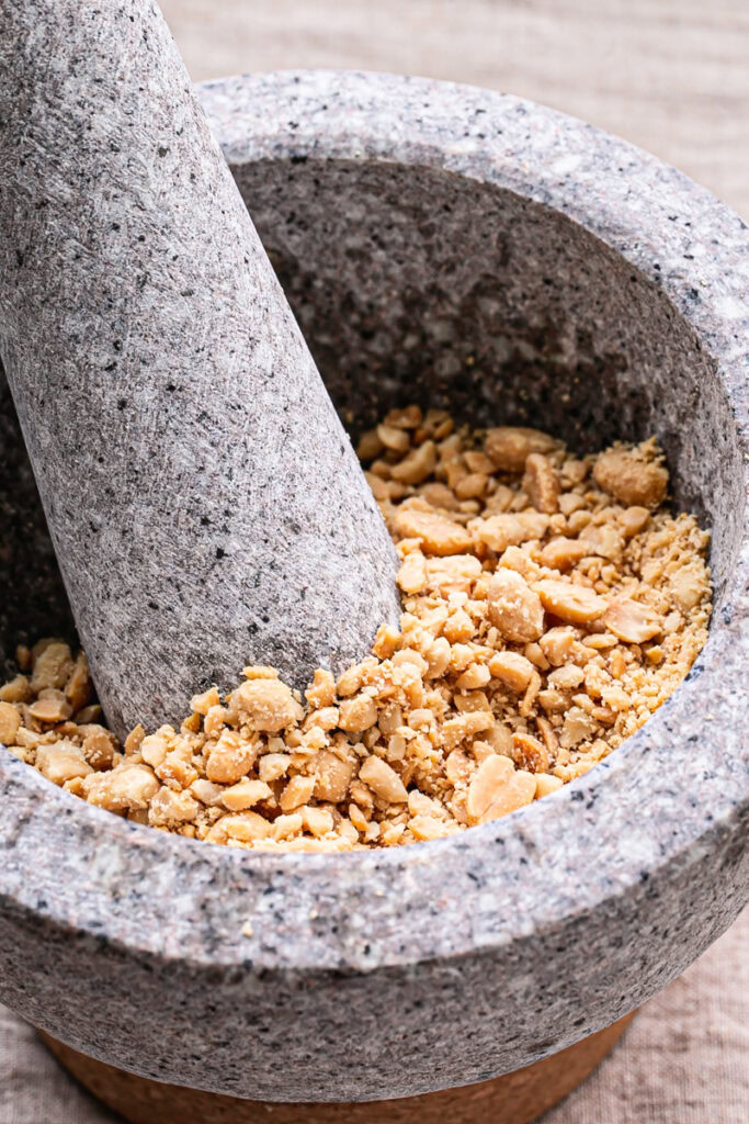 crushed roasted peanuts in a mortar and pestle