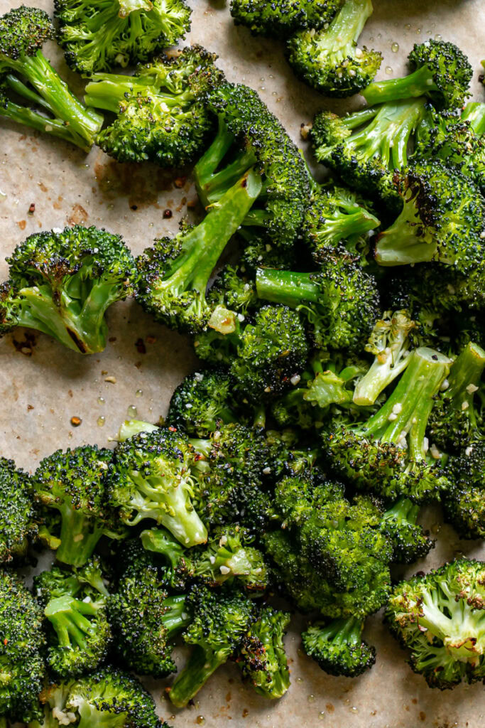 roasted broccoli florets on a baking sheet fresh out of the oven