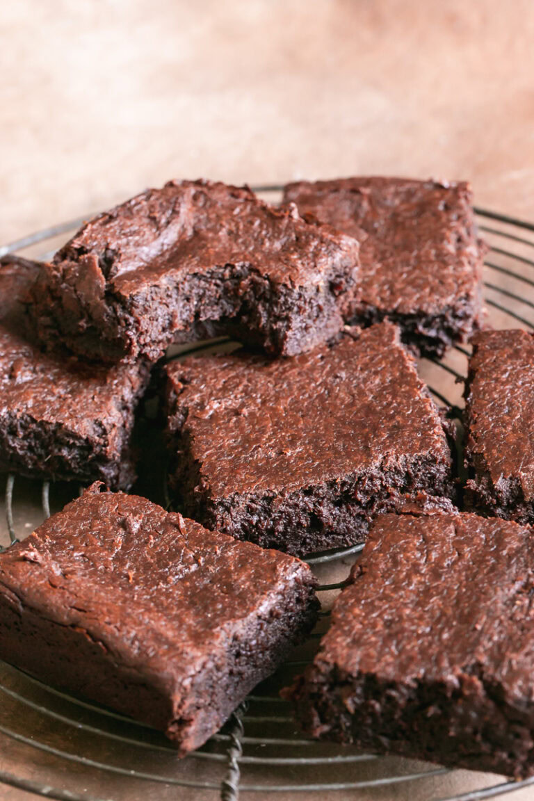 sliced brownies on a round wire cooling rack, one brownie stacked on top of the other with a bite taken out of it
