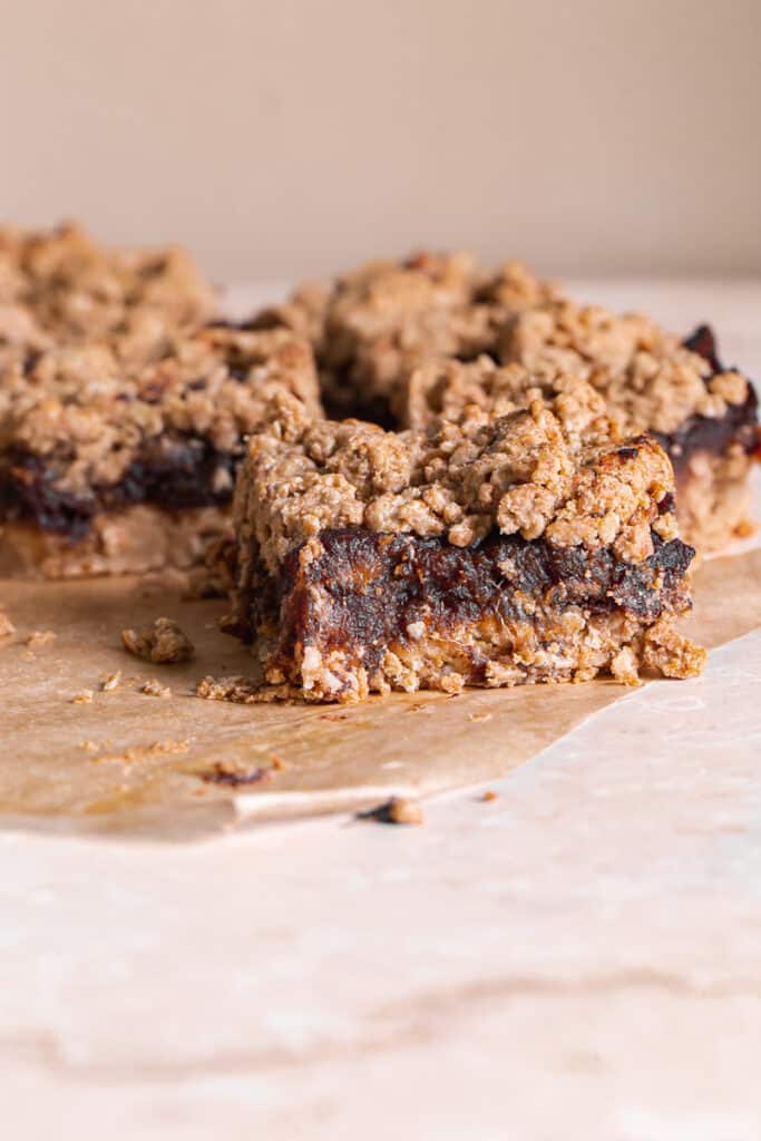 Peanut Butter Oat Date Crumb Bars cut into squares on a piece of parchment paper