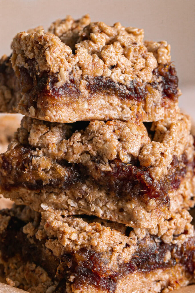 three Peanut Butter Oat Date Crumb Bars stacked on top of one another