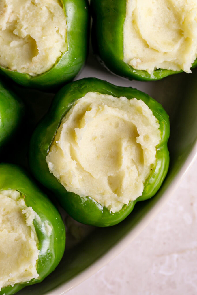 raw green bell peppers filled with the shepherd's pie filling and topped with mashed potatoes
