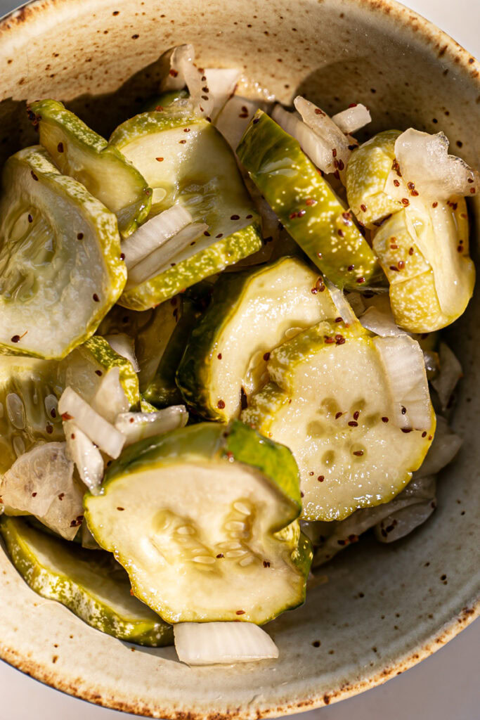 a close up of sweet pickles and onion in a bowl