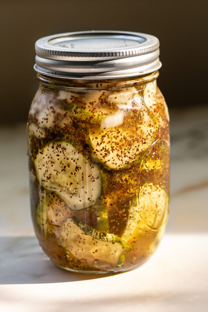 a jar of sweet pickles in the sugar brine covered with a lid