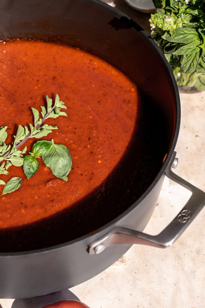 close up of Caramelized Onion and Garlic Roasted Tomato Sauce garnished with fresh basil and oregano