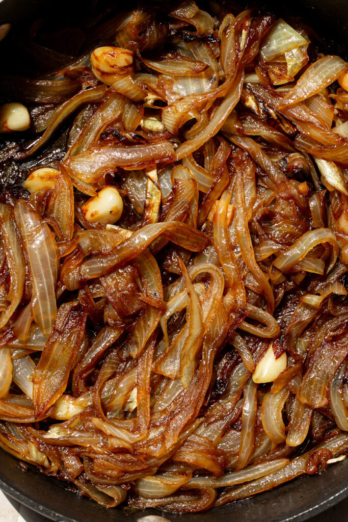 a very close up shot of caramelized onions and garlic in a skillet
