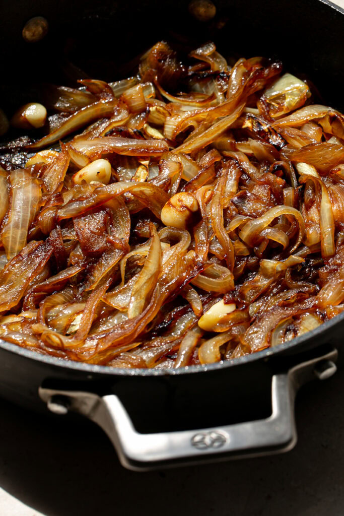 a close up shot of a skillet of caramelized onions and garlic