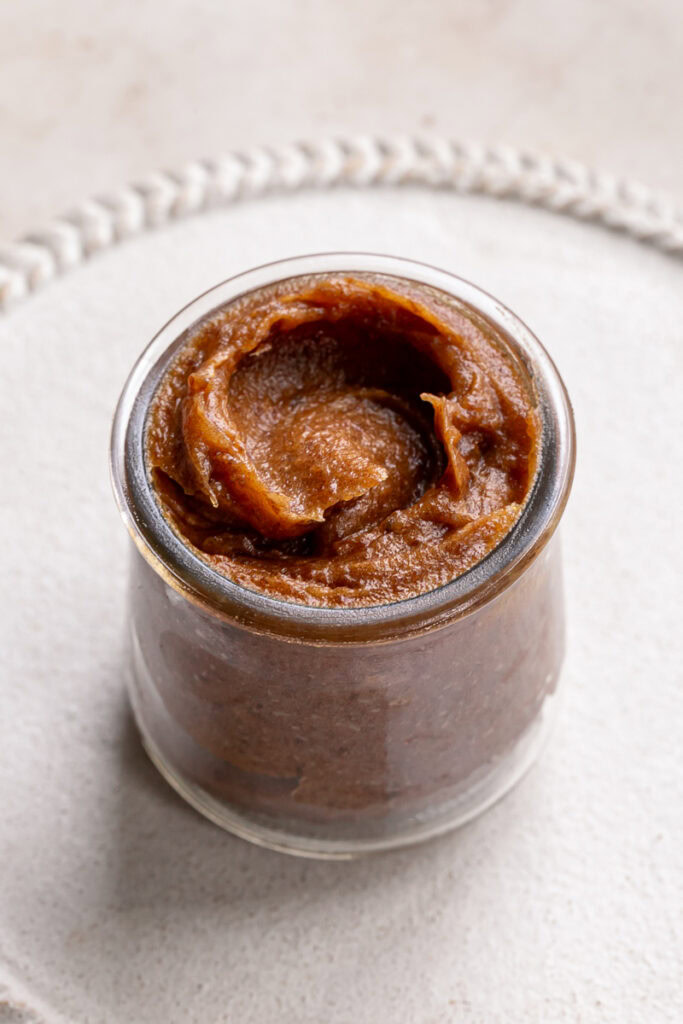 3/4 shot of date caramel in a glass jar