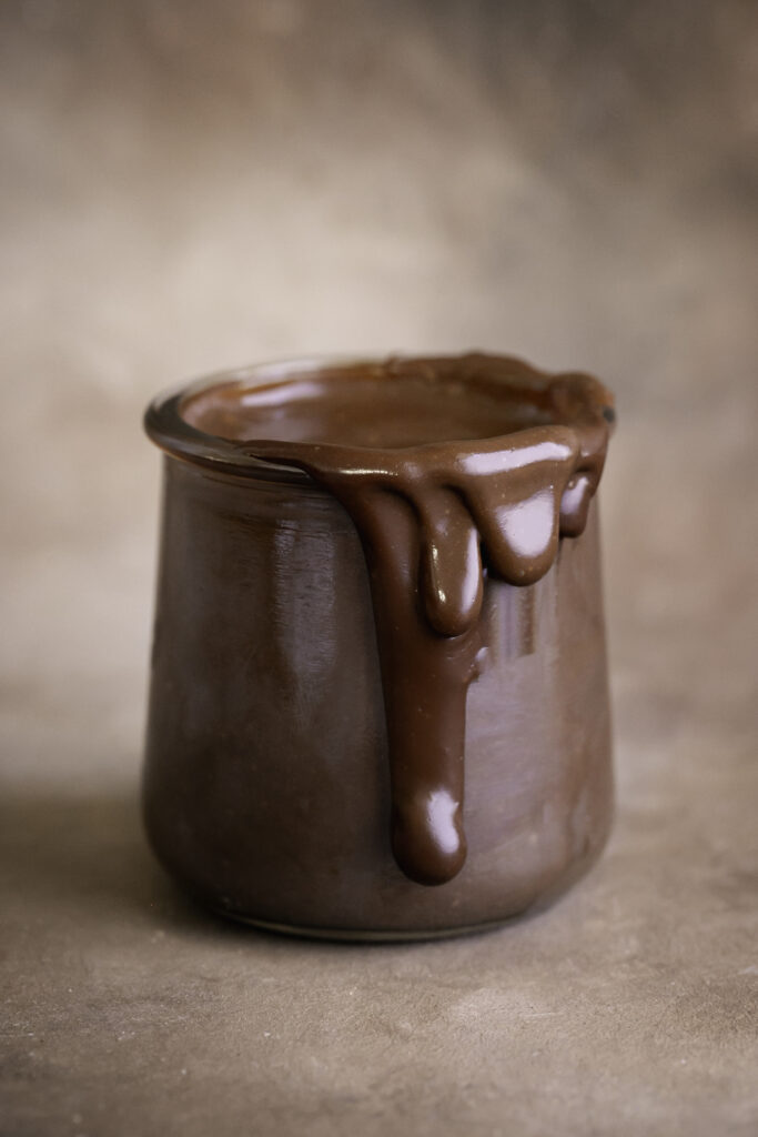 a jar of healthy vegan hot fudge, oozing over the side.