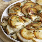 3/4 photo of Pommes Anna skillet potatoes on a plate, sliced